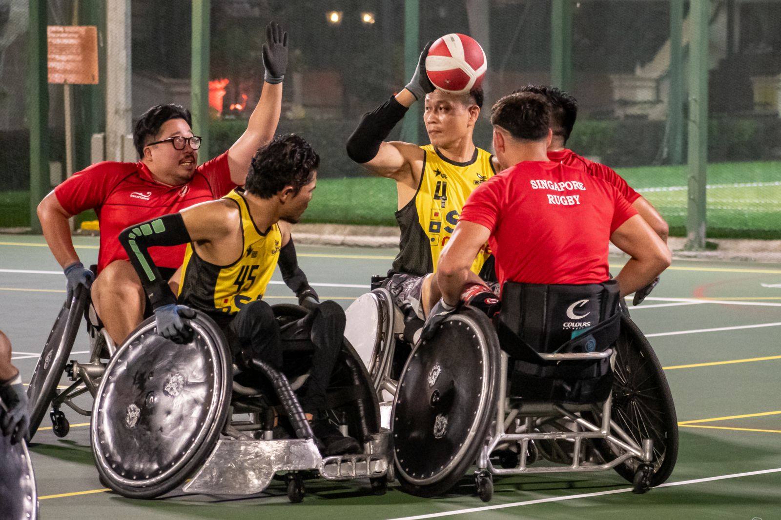 Wheelchair rugby players contesting the ball